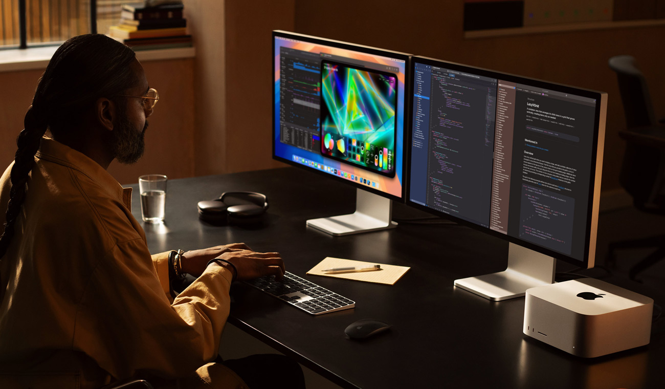 Um profissional a trabalhar num Mac Studio ligado a dois Studio Display