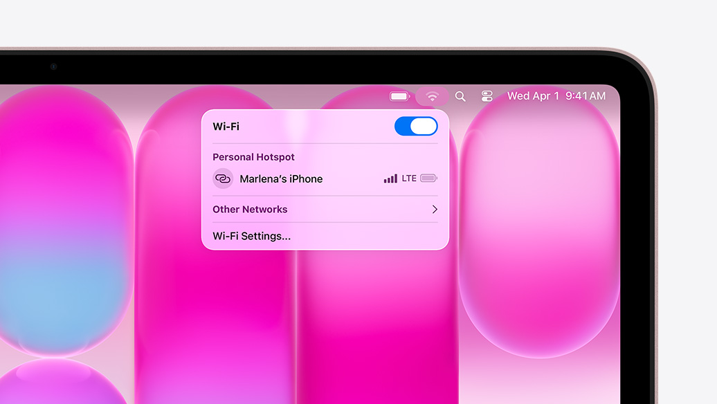 MacBook Neo, warna blush, menu Wi-Fi menampilkan bagian Hotspot Pribadi dengan ”Marlena's iPhone” sebagai opsi yang dapat dipilih
