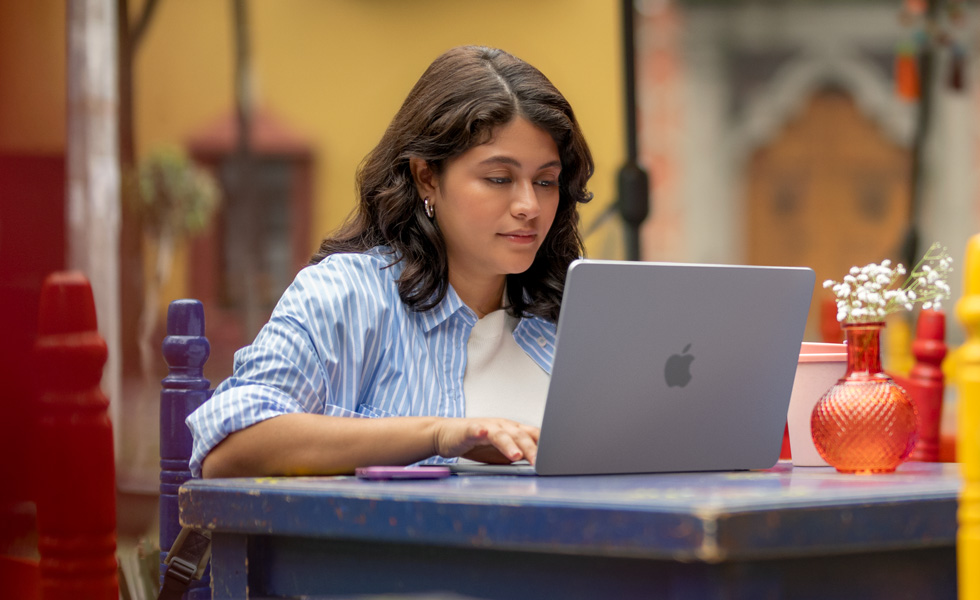 Una estudiante escribe en su MacBook