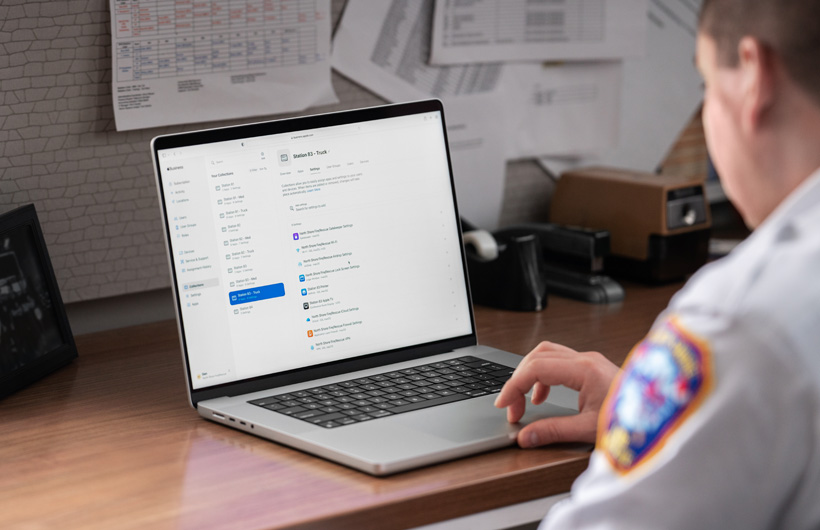 Líder do corpo de bombeiros no escritório usa um MacBook com o Apple Business Essentials aberto na tela