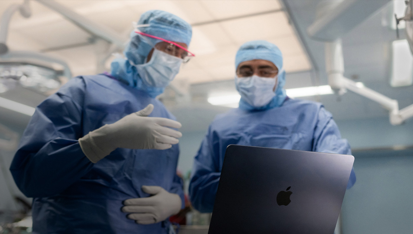 Twee chirurgen bespreken iets op het scherm van een MacBook Pro in de OK.