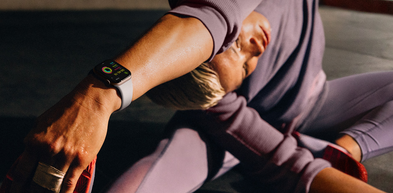 Een vrouw draagt een Apple Watch tijdens het stretchen.