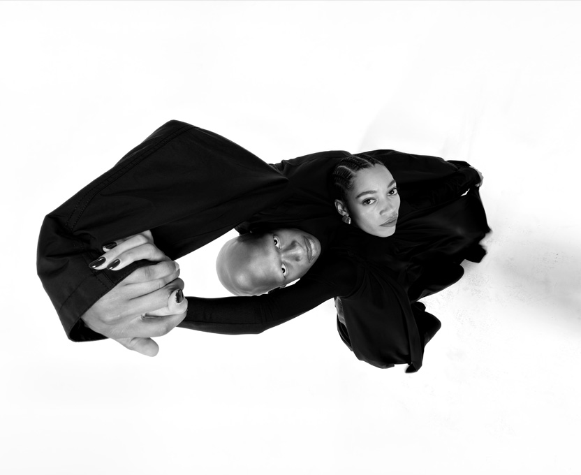 Photo grand-angle en noir et blanc de deux personnes illustrant les capacités de la caméra ultra grand-angle d’iPhone 17 Pro